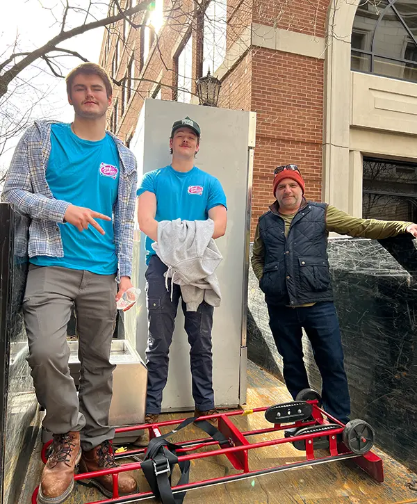 Junk removal crew posing during appliance hauling and commercial cleanout service