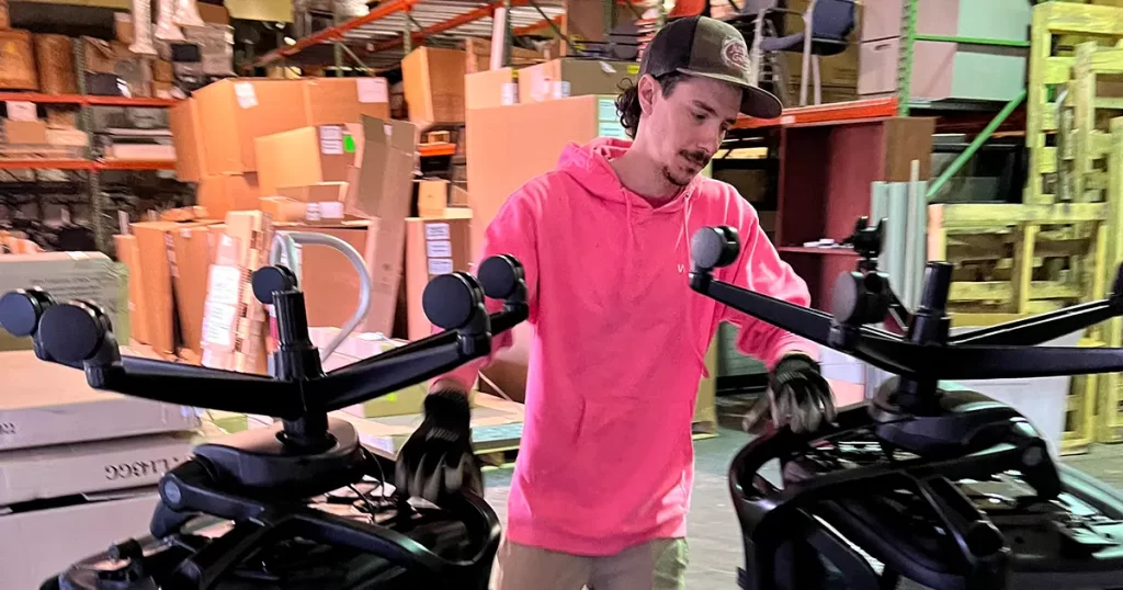 Junk removal worker moving office chairs during commercial furniture removal and cleanout service