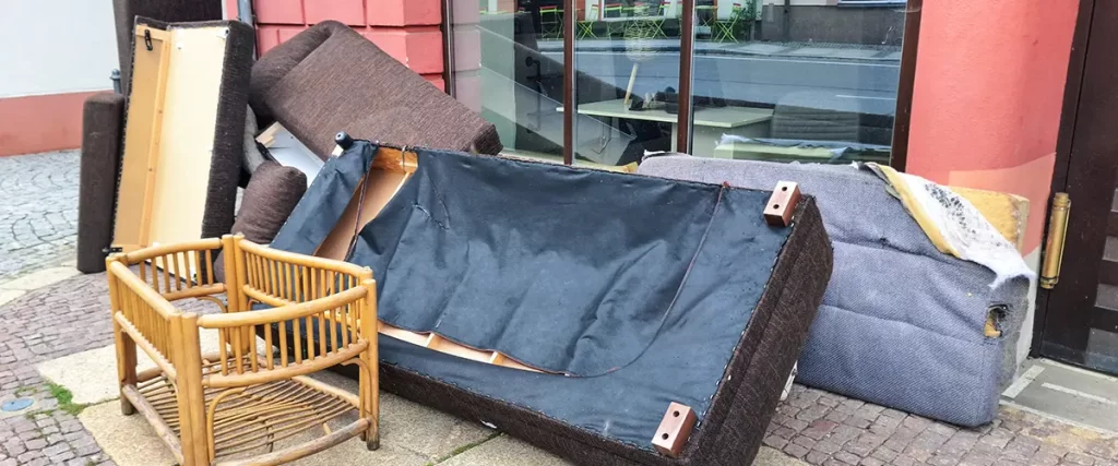 Old couches, chairs, and unwanted furniture placed outside for furniture removal and disposal